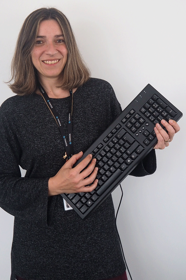 Mulher a segurar um teclado de computador