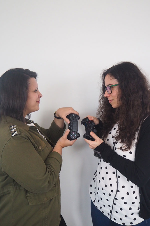 Duas mulheres a fingir que estão a utilizar comandos de consolas